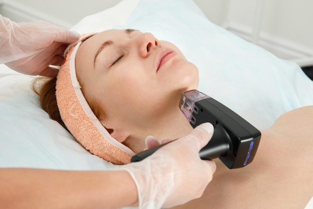 Fractional mesotherapy of the facial skin RF skin lifting Procedure in a cosmetology clinic The procedure of hardware liposuction of the neck and chin Removal of the second chin in a woman