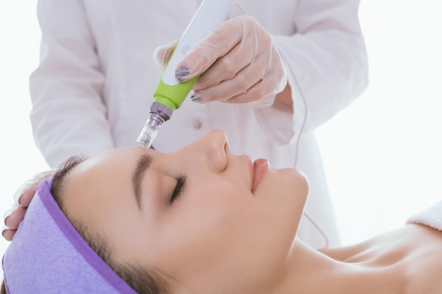 Fractional mesotherapy A young beautiful woman in the cosmetologist office Hardware cosmetology