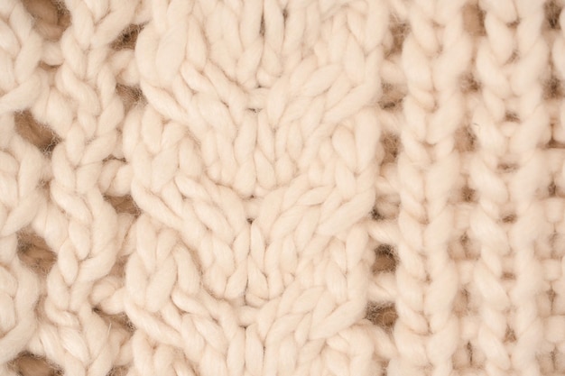 A fragment of beige knitted fabric knitted from white sheep wool