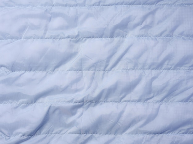 A fragment of blue fabric with down filling and stitching fabric for jackets and coats