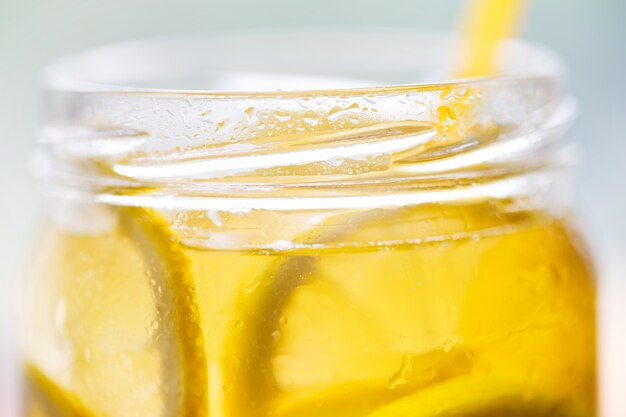 Fragment of a can of cold lemonade with a straw