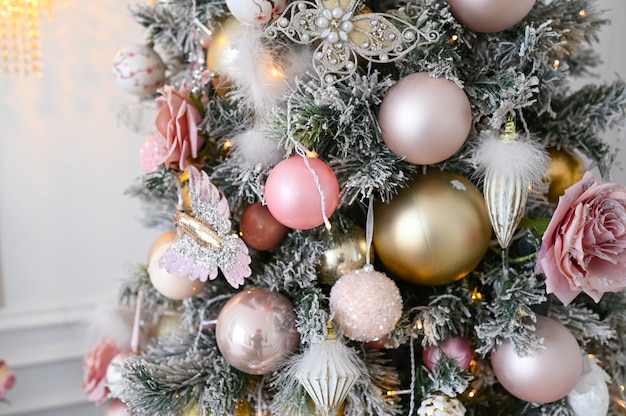 A fragment of a Christmas decorated tree in soft pink colors