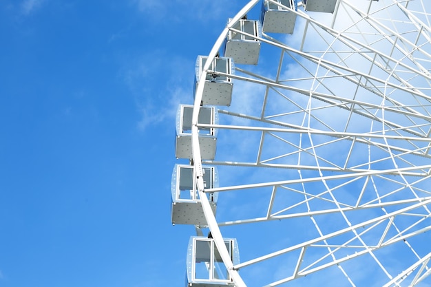 Fragment of a ferris wheel against the blue sky