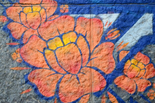 Fragment of graffiti drawings The old wall decorated with paint stains in the style of street art culture Orange flower