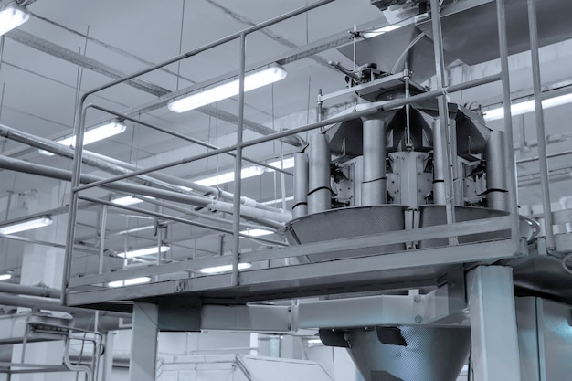 Fragment of an industrial machine for the automatic packing of candies in the shop of a confectionery factory