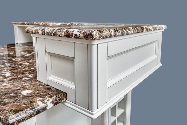 Fragment of kitchen island in country style with granite countertops isolated on gray background