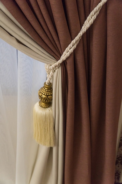 Photo fragment of luxurious curtains with fringe and tassel