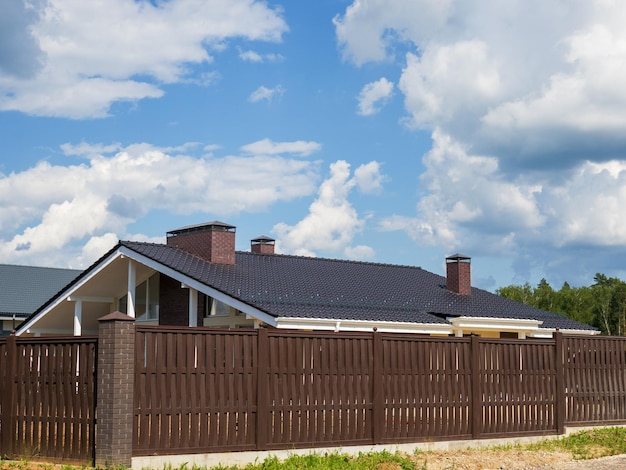 A fragment of a metaltile roof with three chimneys