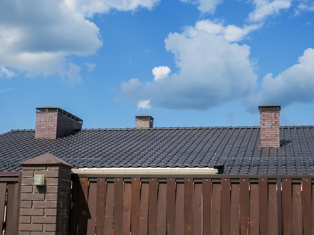 A fragment of a metaltile roof with three chimneys