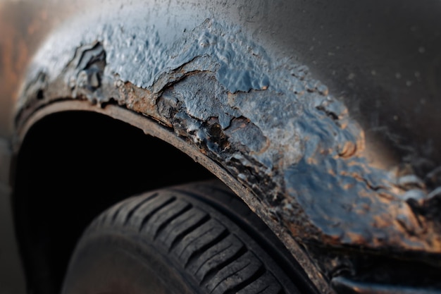 A fragment of a rusty car fender Aggressive corrosion Selective focus Photo in a dark key