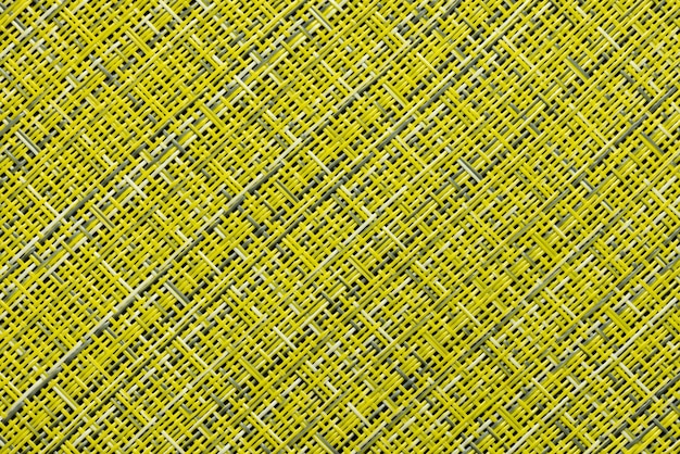 A fragment of a straw rug, as a background or texture, yellow and gray color, close-up.