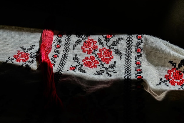 Fragment of Ukrainian national dress Vyshyvanka ethnic clothing with embroidery patterns red and black threads Closeup shot copy space