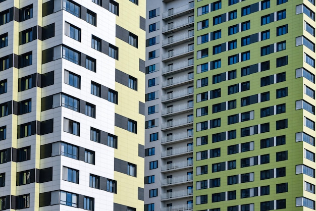 Fragments of high-rise buildings with windows and balconies close-up.