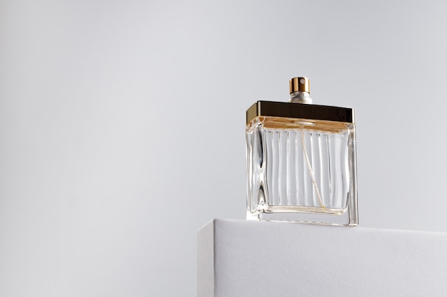 Fragrance bottle on gray block against gray background