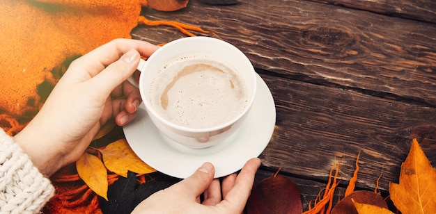 fragrant coffee in your hands against the background of autumn