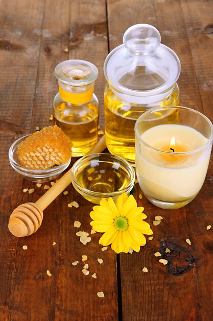 Fragrant honey spa with oils and honey on wooden table closeup