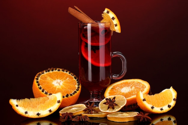 Fragrant mulled wine in glass with spices and oranges