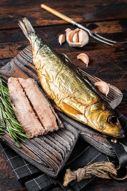 Fragrant Smoked herring fish fillet on wooden board with herbs Wooden background Top view