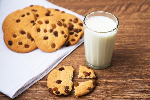 Fragrant tasty homemade cookies with raisins and a glass of fresh milk on the white kitchen towel