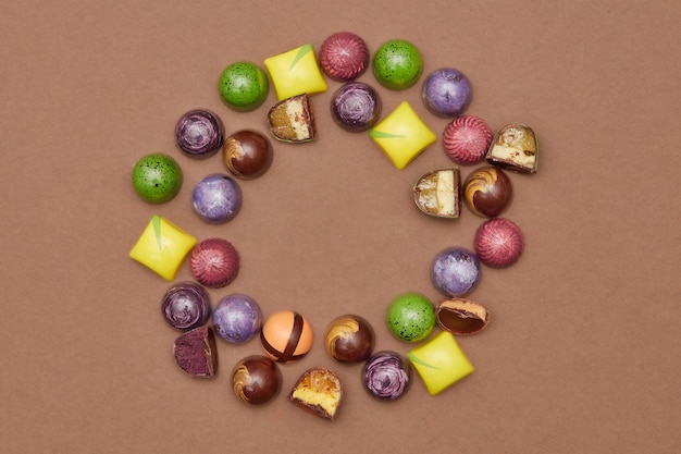 Frame of chocolates on a brown background.