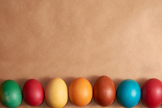 Frame colorful Easter eggs on brown background