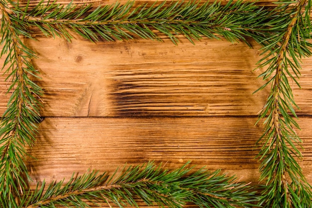 Photo frame of the fir tree branches on rustic wooden table