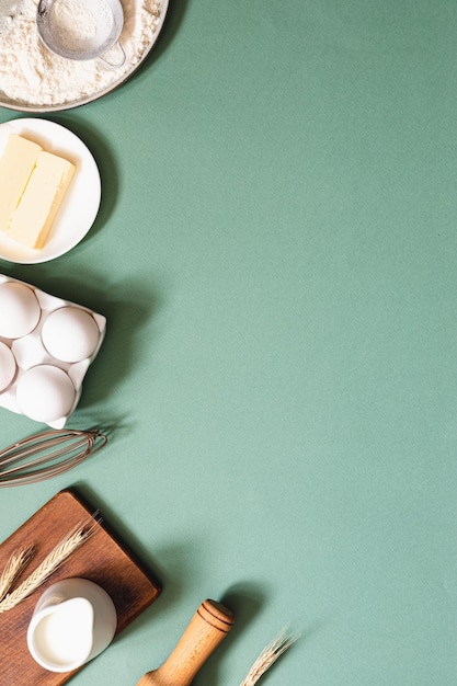 Frame of food ingredients for baking on a green pastel background Cooking flat lay with copy space Top view Baking concept Mockup