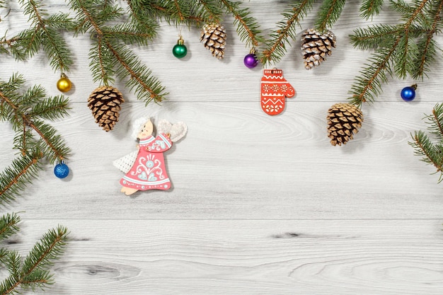 Frame from natural fir tree branches with Christmas ornament on gray background