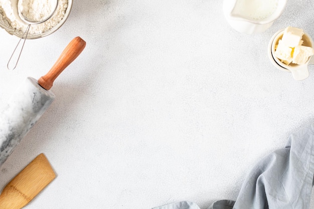 Frame made of ingredients for home baking The concept of baking is a marble rolling pin flour butter water on a white background Top view