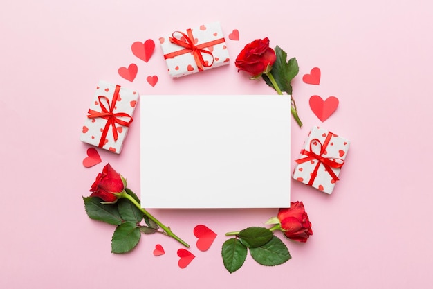 Frame made of rose git box heart and blank greeting card mockup on Colored background Top view flat lay copy space Holiday Mothers Day birthday concept