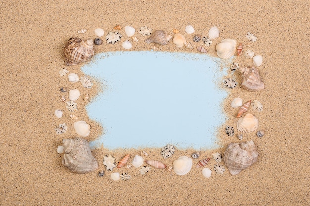 Photo frame made of seashells on the sand