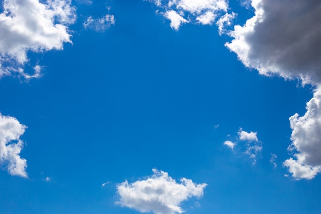 Frame made of white clouds against a bright blue sky. Space for text, copy space.