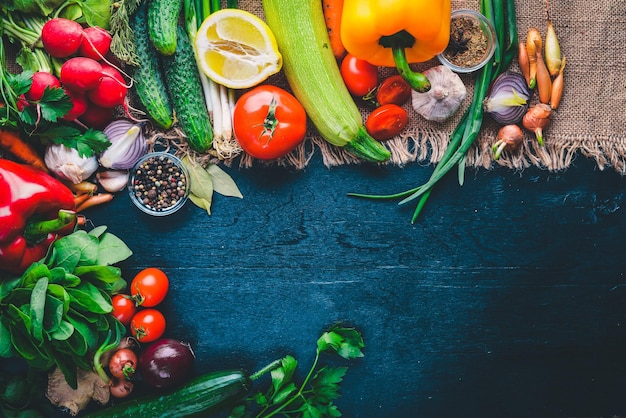 Frame of organic food Fresh raw vegetables and spices On a wooden chalkboard