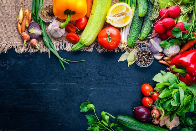 Frame of organic food. Fresh raw vegetables and spices. On a wooden chalkboard.