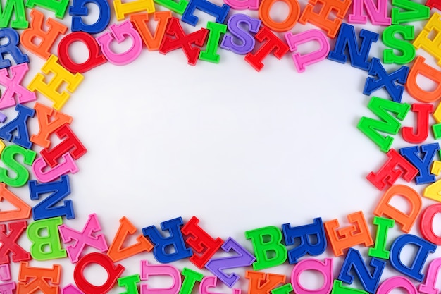 Frame of plastic colorful alphabet letters on a white background