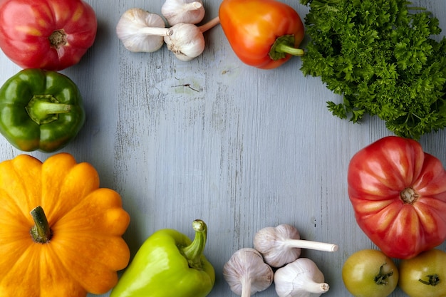 Frame of ripe vegetables from the garden bed on a blue wooden background. Harvest festival