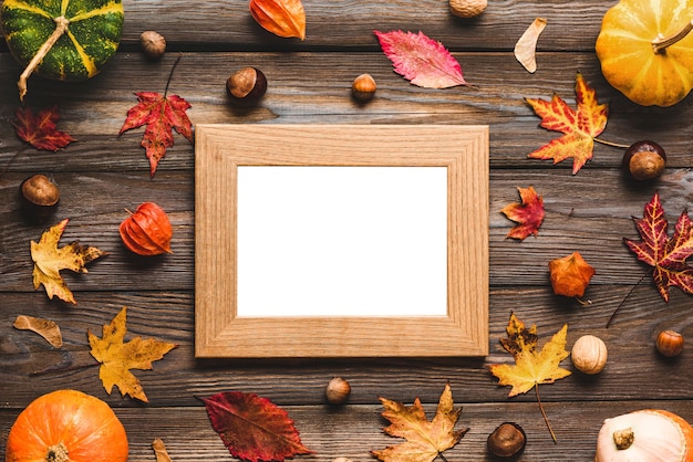 Frame surrounded by pumpkins, fall leaves and nuts