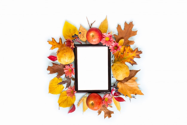 A frame of various colorful autumn fruits and leaves over light blue