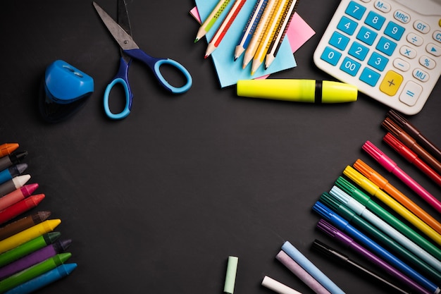 Frame with school supplies on Blackboard background. Top view