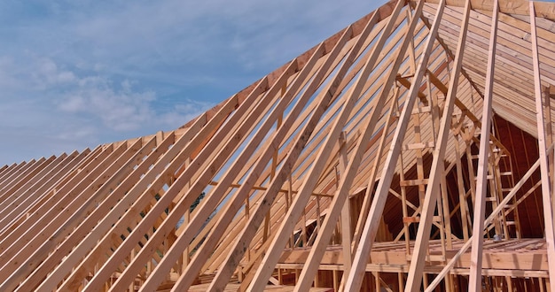 Framework of beam framing unfinished roofing for new home with wooden truss