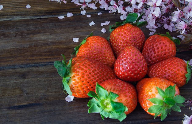  Frash strawberry on wooden table with flower