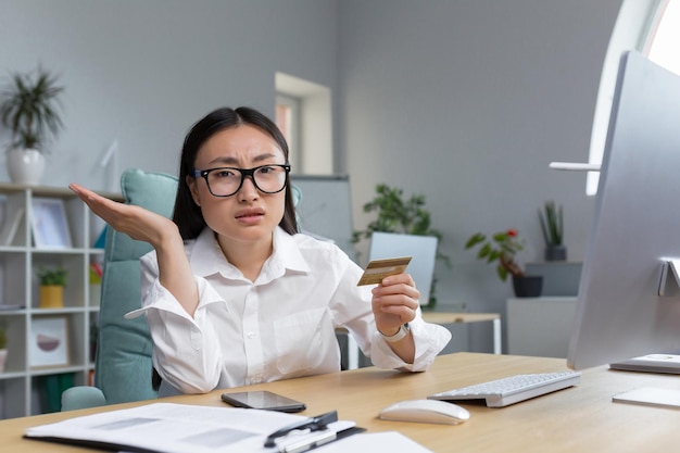 Fraud upset young beautiful asian woman holding a credit card a disappointed young lady lost her