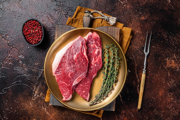 Freah Raw cap rump beef meat steak in a plate with thyme top sirloin steak Dark background Top view