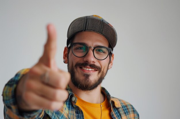 Free photo indoor shot of positive person in casual red tshirt points with index finger aside