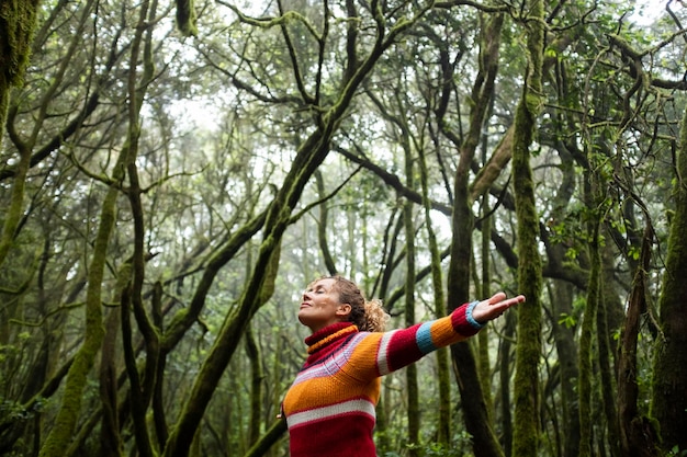 Freedom and happiness lifestyle and moment Standing middle age young woman open arms and smile Success life and nature feeling Outdoors nature lover Protect woods and sustainabiliy future