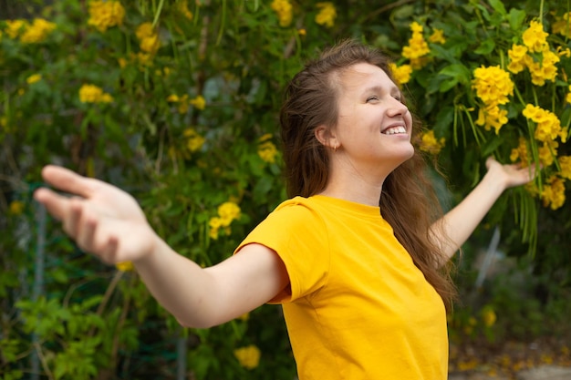 Freedom happy woman feeling alive and free in nature breathing clean and fresh air Carefree young adult smile in garden or park showing happiness with arms raised up Spring allergies concept