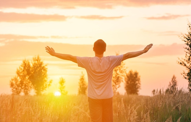 Freedom A man looks at the setting sun with his arms outstretched