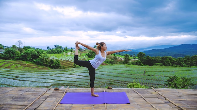 Freedom traveler woman relax in the holiday. Play if yoga Stand landscapes natural on the mountains and Field Rice.