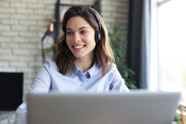 Freelance operator talking with headsets and consulting clients from home office.