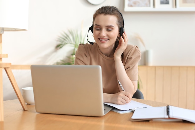 Freelance operator talking with headsets and consulting clients from home office.